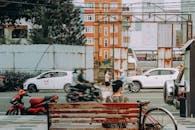 Woman Sitting on Bench by Busy Street