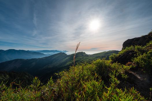 Breathtaking sunrise over lush Taiwanese mountains with expansive sky and greenery.