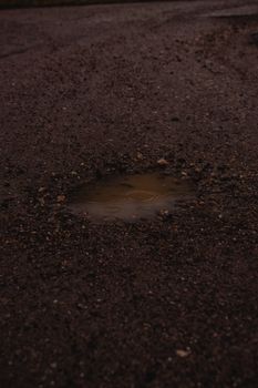 特写镜头：芬兰赫尔辛基碎石路上雨水泛滥的水坑
