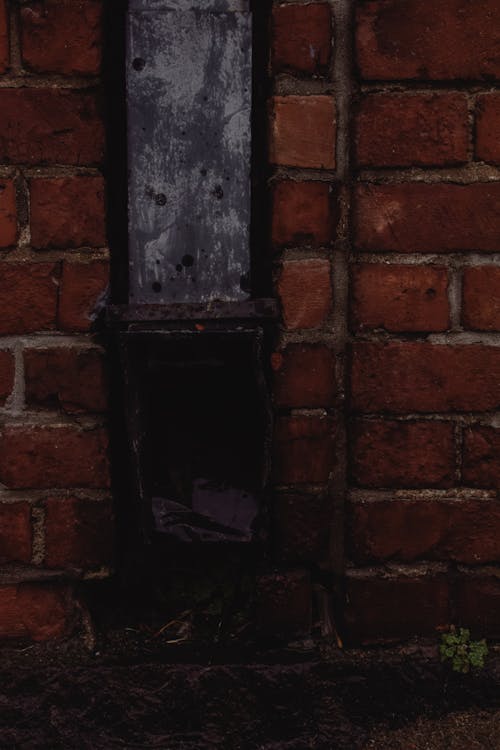 Черная деревянная дверь на коричневой кирпичной стене