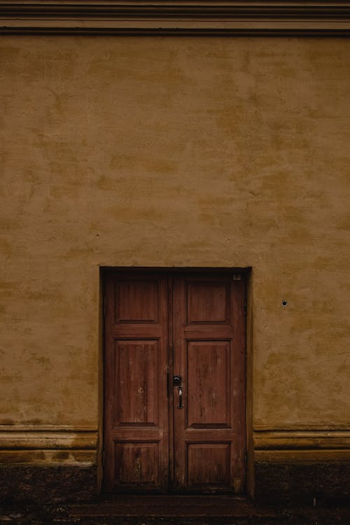 茶色のコンクリートの壁に茶色の木製のドア