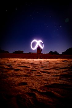 在瓦迪拉姆沙漠的星空下，一幅男子光画捕捉了夜晚的美丽