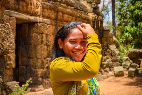 A Woman Smiling Touching her Head