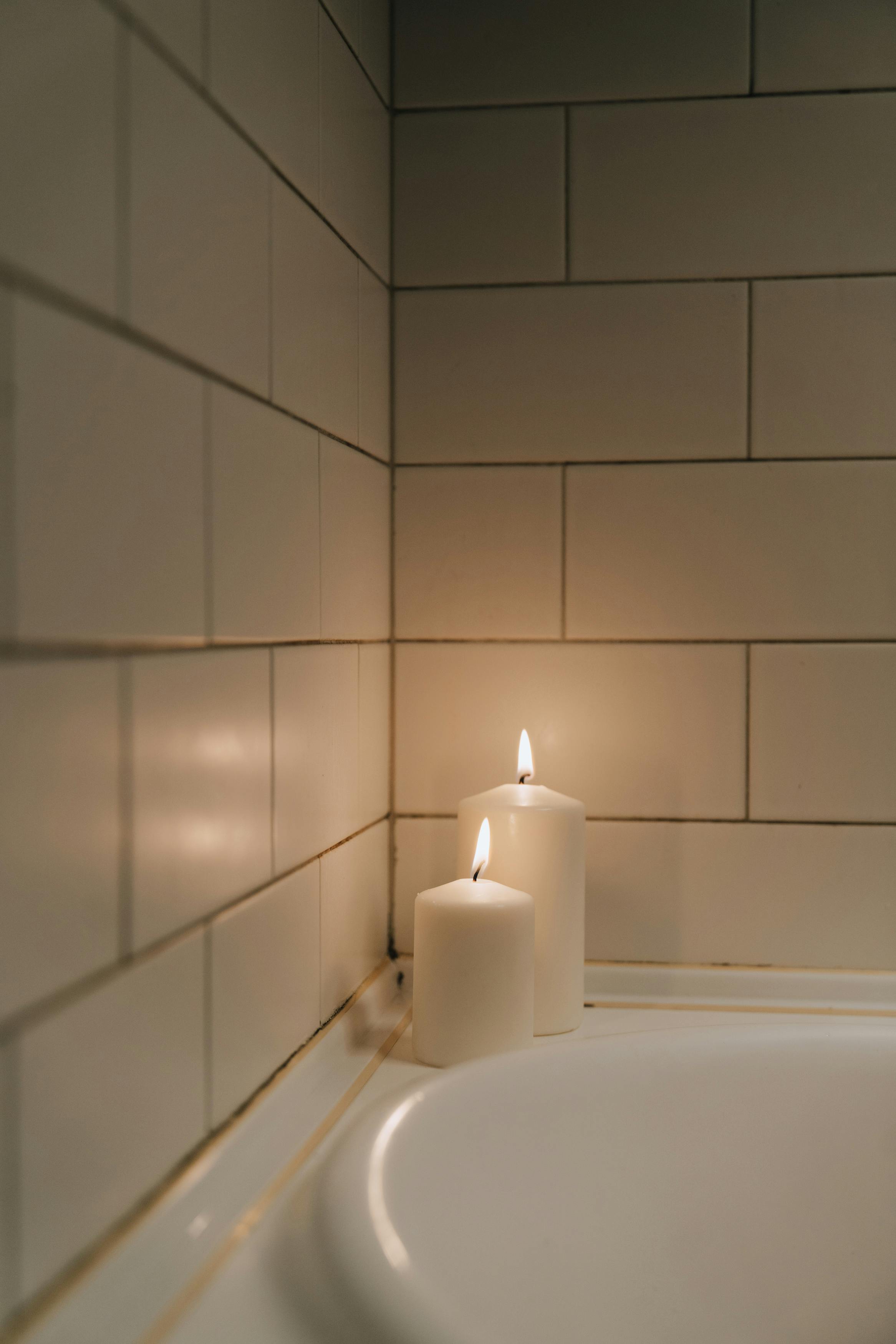 Free Serene candlelit ambiance in a modern tiled bathroom corner, perfect for relaxation. Stock Photo