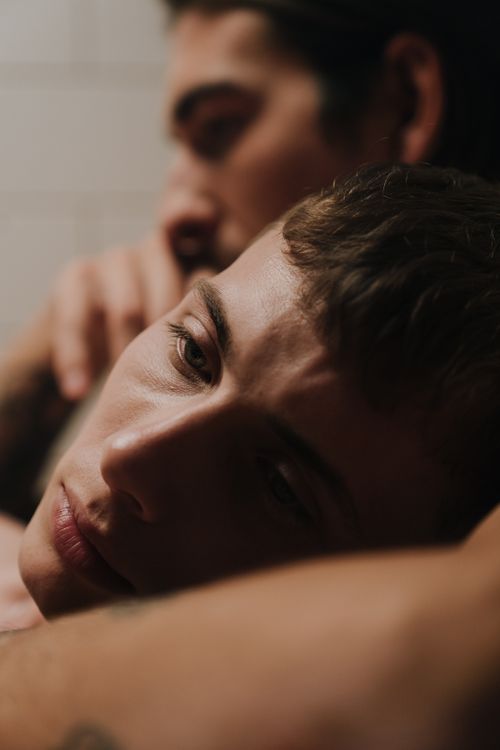 Free Close-up of two men embracing, conveying intimacy and connection. Stock Photo