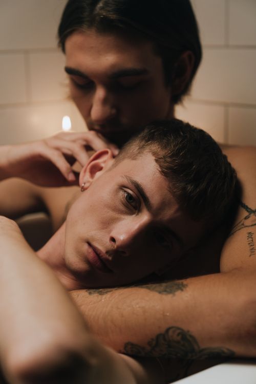 Free Tender moment of affection between two men in a cozy setting, evoking warmth and closeness. Stock Photo