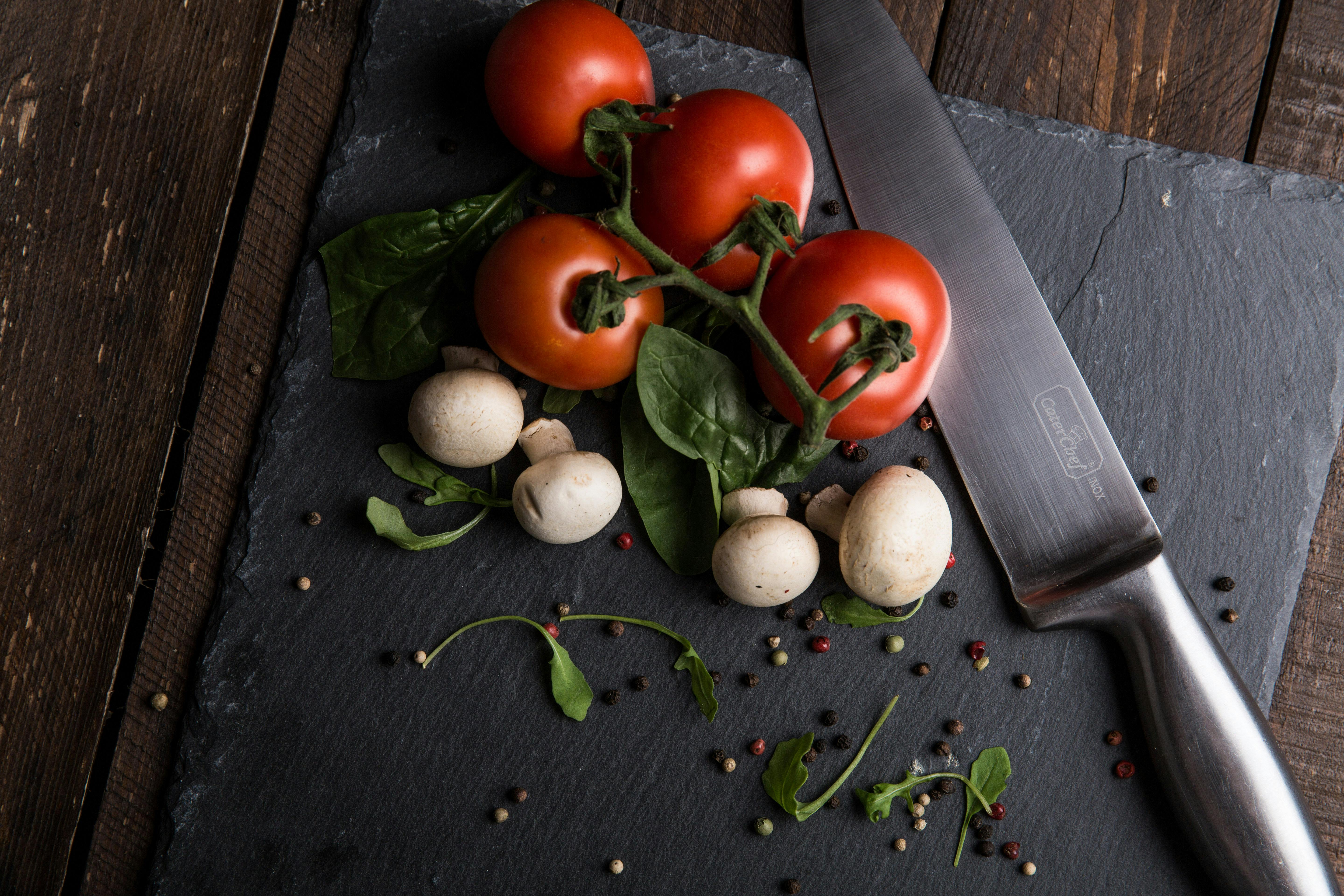 red tomatoes mushrooms and gray steel knife