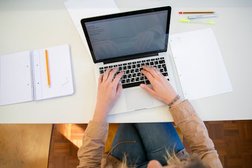 Free Woman working on laptop with documents Stock Photo