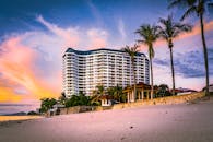 海滨度假胜地的壮丽景色中，棕榈树映衬着充满活力的日落