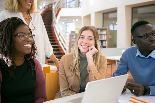 노트북에 팀에서 일하는 다민족 학생 미소