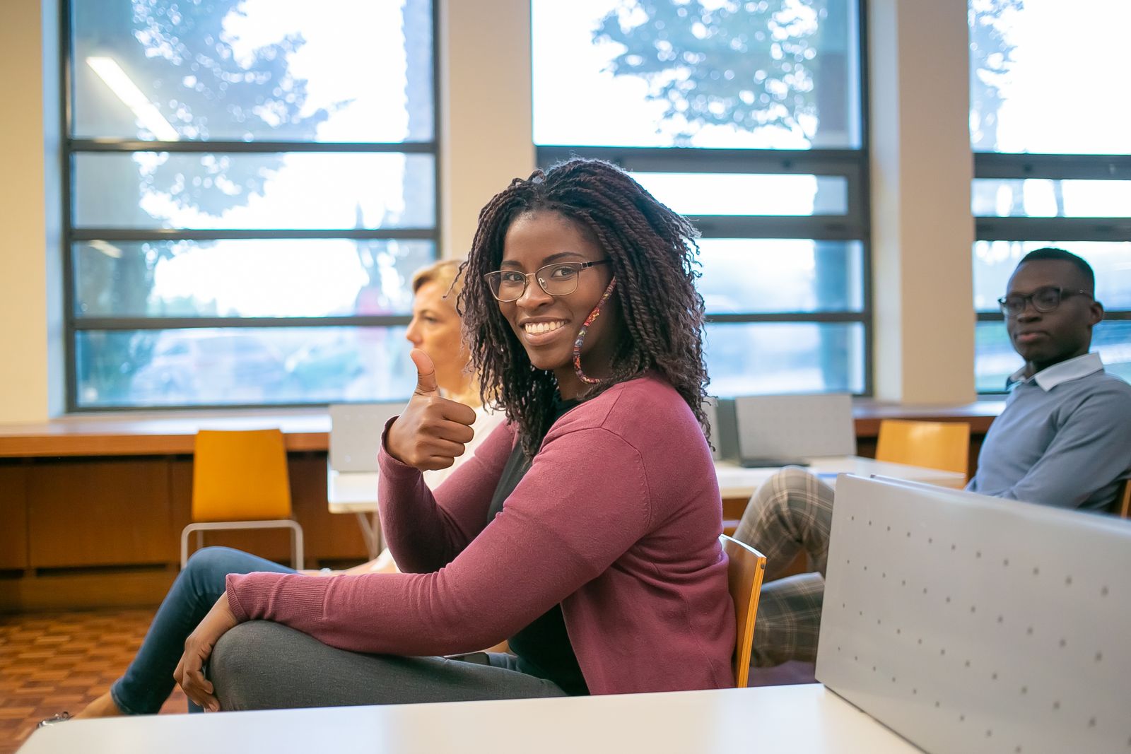 Students in a modern classroom smiling toward the camera.