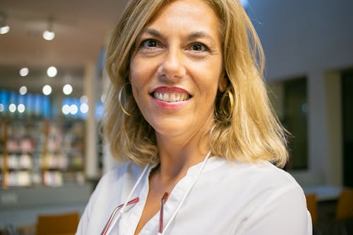 Positive woman smiling to camera in modern library