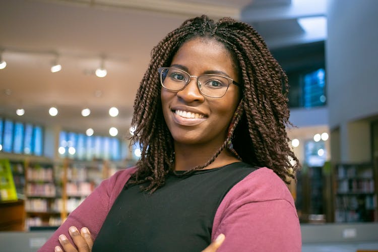 Smiling Black Woman With Pigtails In Library