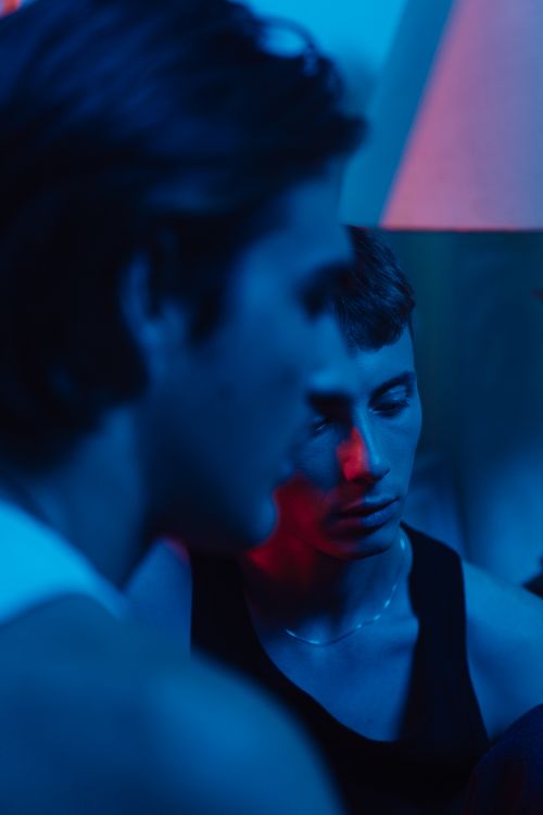 Free Close-up portrait of two men in dramatic blue and red lighting. Stock Photo