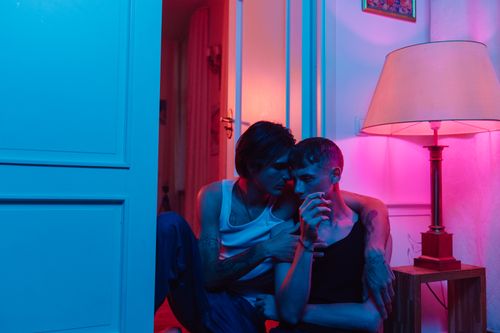Free A loving couple shares an intimate moment indoors with colorful lighting. Stock Photo