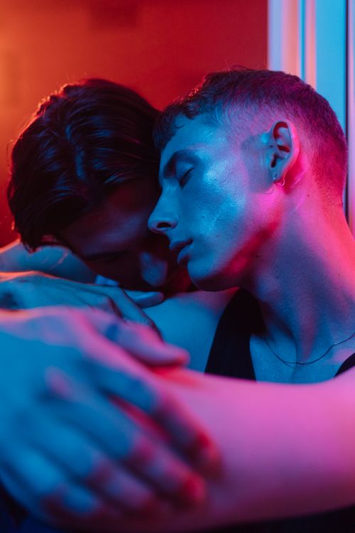 Free Romantic couple embracing with vibrant neon lighting, showcasing affection and connection. Stock Photo