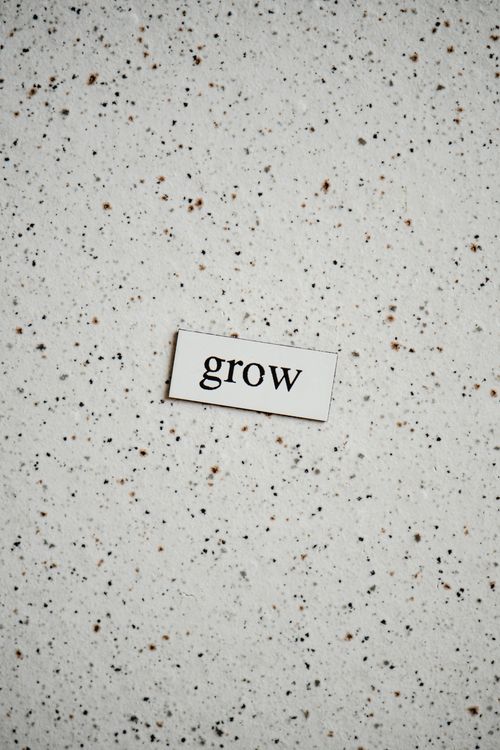Free Minimalist background with the word "grow" on a speckled surface, inspiring growth and potential. Stock Photo