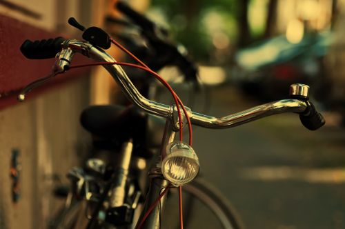 Free Close-up view of a parked vintage bicycle with a shiny chrome handlebar and classic headlamp. Stock Photo
