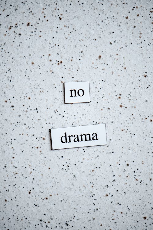 Words Saying "No Drama" on White Plaques on White Background with Black Dots 