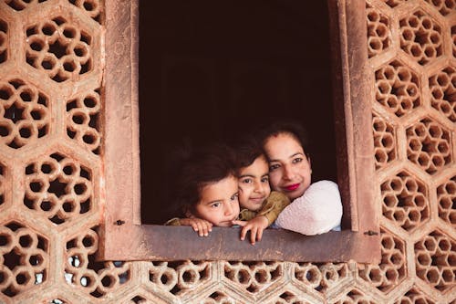 Mother and Children Looking Outside Through A Concrete Window