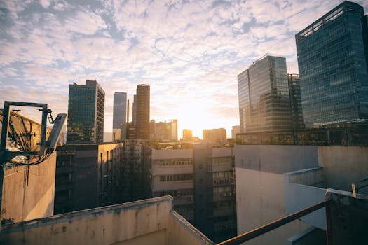 A vibrant city skyline at sunrise, featuring modern skyscrapers and clear skies.