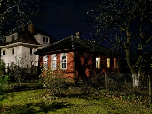 Old Wooden House with Light Inside at Night