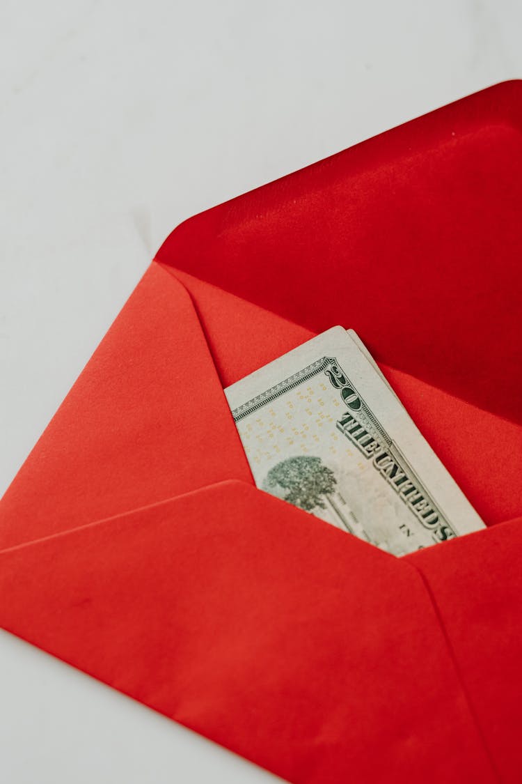 Close-Up Photo Of A Twenty Dollar Bill In A Red Envelope