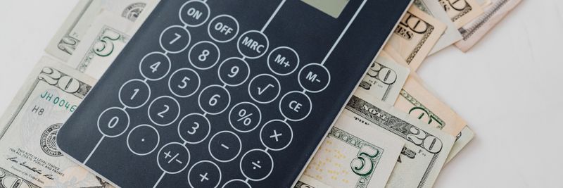 Close-up of a calculator atop US dollar bills, symbolizing financial planning and budgeting.