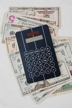 A calculator placed on US dollar banknotes, symbolizing financial planning and money management.