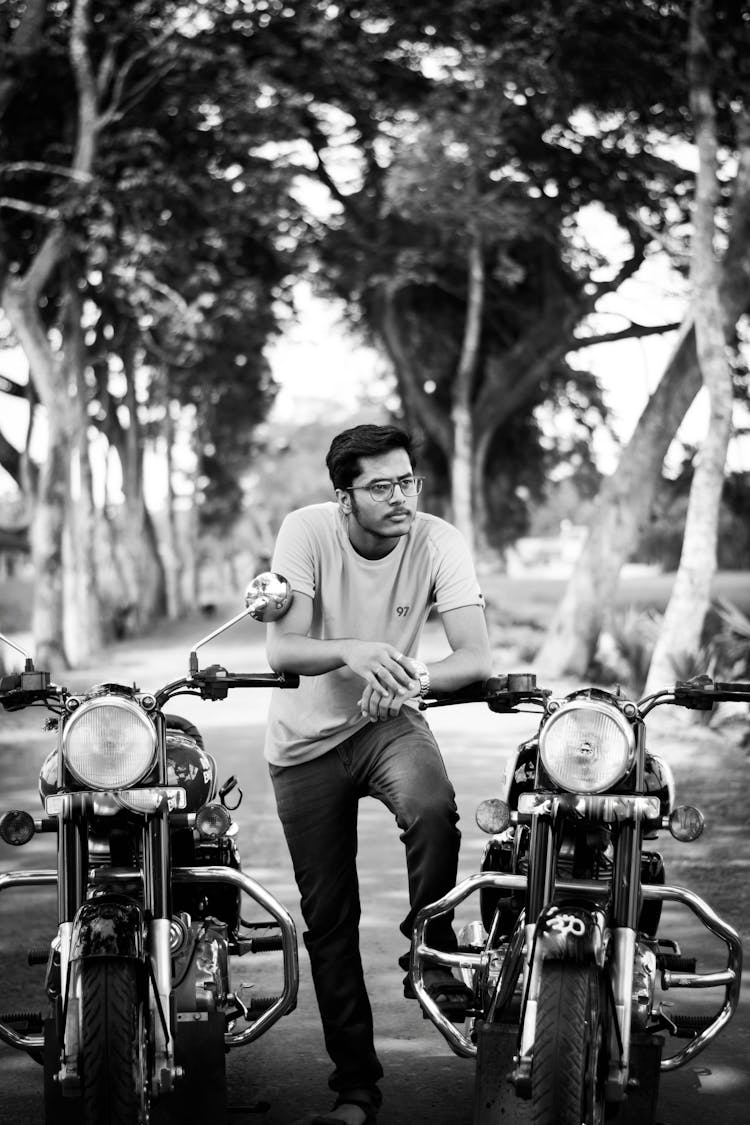 A Man Leaning On Motorcycle Handlebars