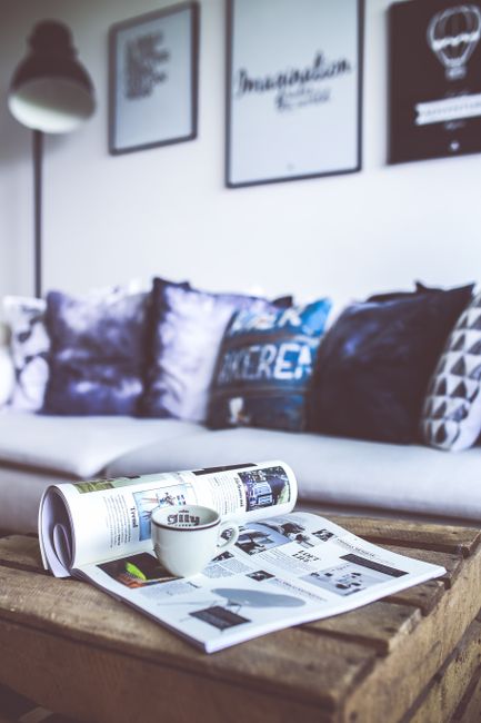 Fotomural Una escena relajante de sala de estar con una revista y café sobre una mesa de madera.