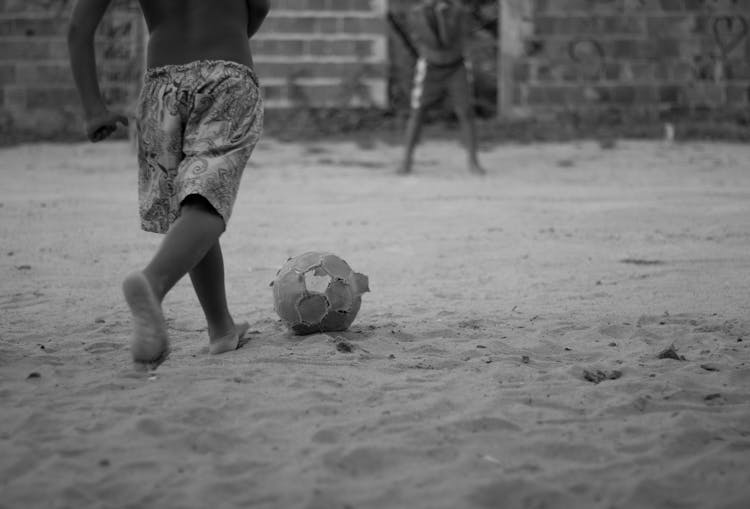 A Person Kicking A Tattered Ball