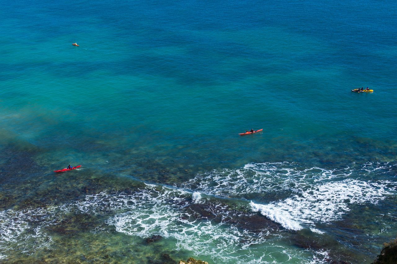 a stunning aerial view of people kayaking above clear ocean waters nea