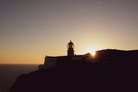 A beautiful silhouette of a lighthouse at sunset on the coast of Portugal, capturing the golden hour ambiance.