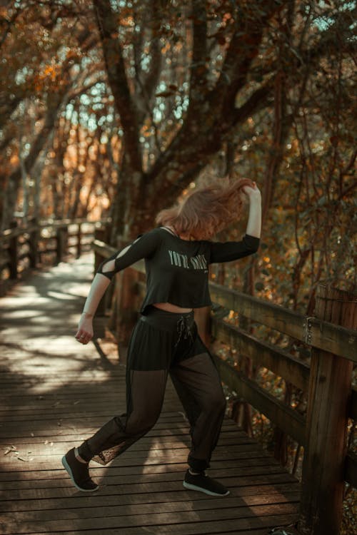 Безкоштовне стокове фото на тему «вертикальні постріл, дерев’яна пішохідна доріжка, жінка»