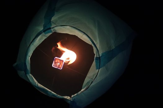 一盏灯笼在漆黑的夜空中闪闪发光，象征着希望与庆祝