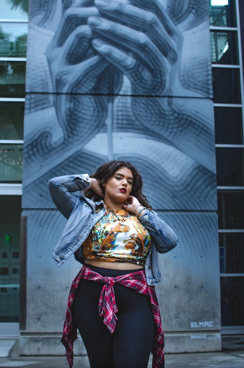 Ethnic female standing near graffiti wall in day