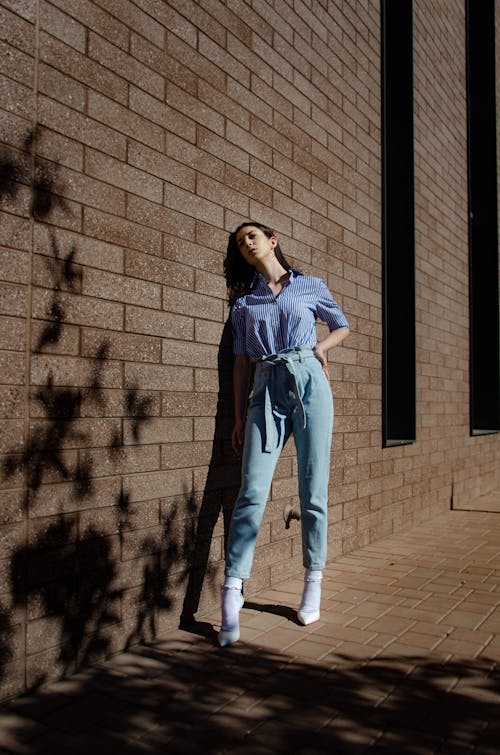 Confident female standing near wall in daylight