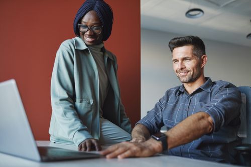 Free Professional team working together at a laptop in a modern office environment. Stock Photo