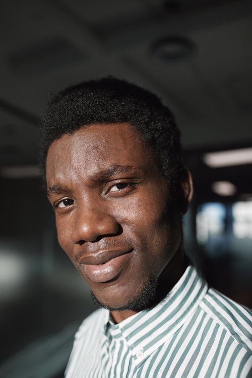Free Close-up shot of a smiling man wearing a striped shirt, captured indoors with warm lighting. Stock Photo