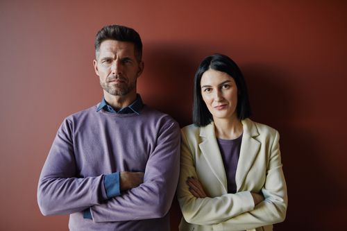 Free Portrait of a man and woman confidently posing in a modern office. Stock Photo
