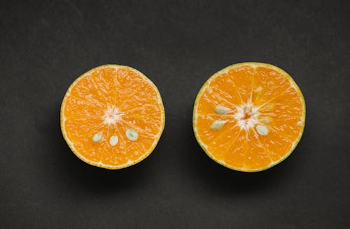 Top view of fresh cut juicy orange with sweet pulp placed on black background