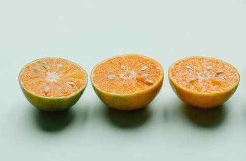 Halves of fresh ripe citruses in row