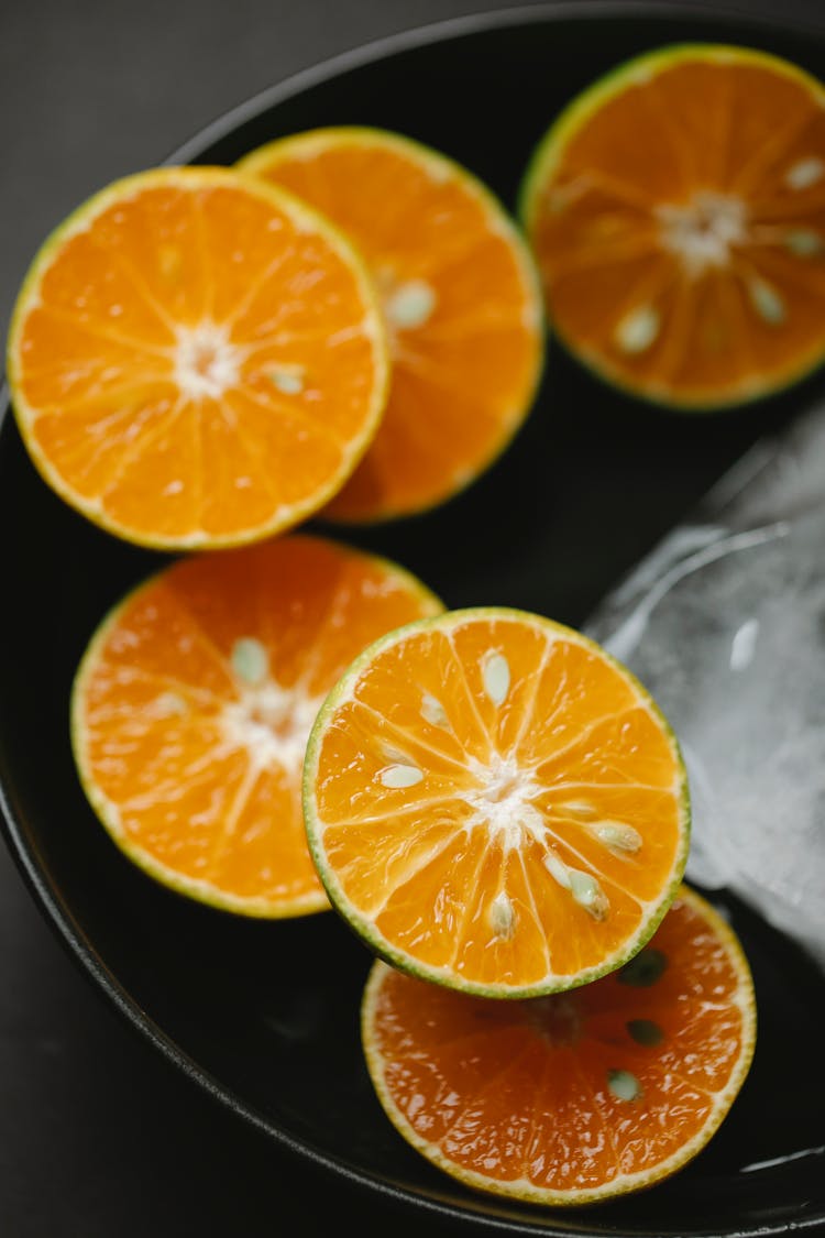 Slices Of Fresh Orange Near Ice In Bowl