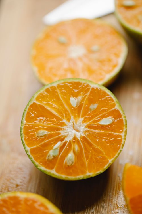 Free From above of cut tasty citruses placed on wooden board in kitchen for healthy lunch Stock Photo