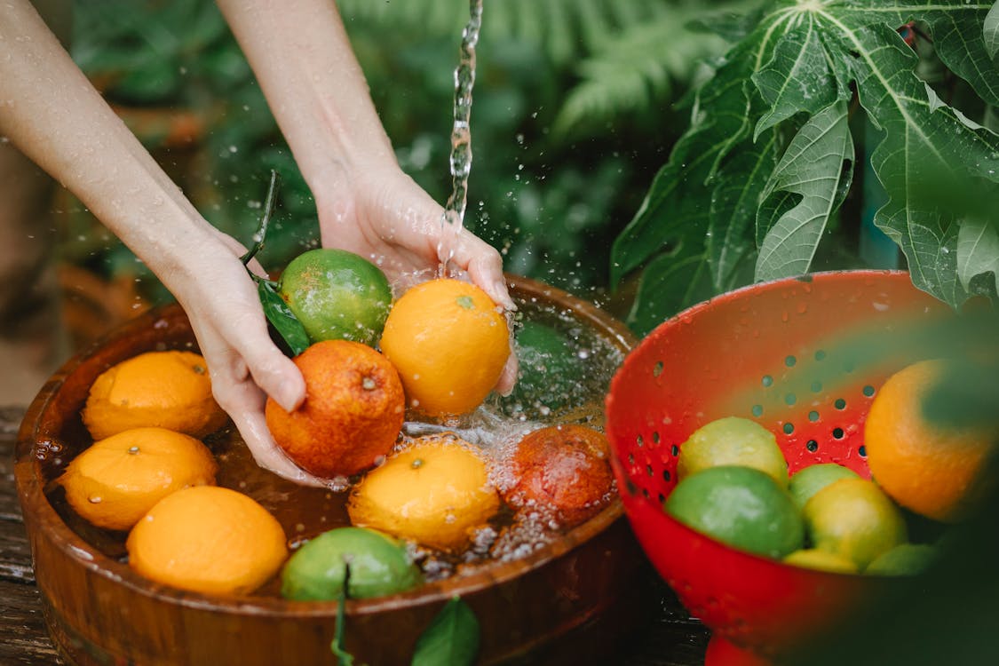 Free Woman washing fresh fruits in tropical orchard Stock Photo