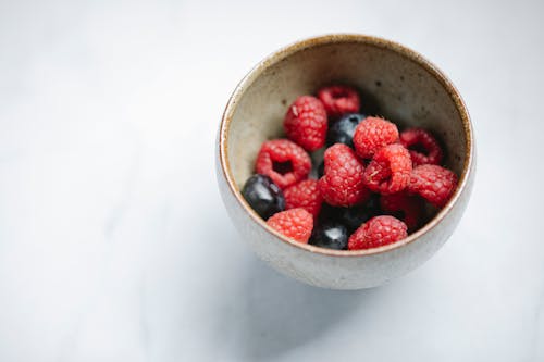 Fresh raspberries and blueberries in bowl