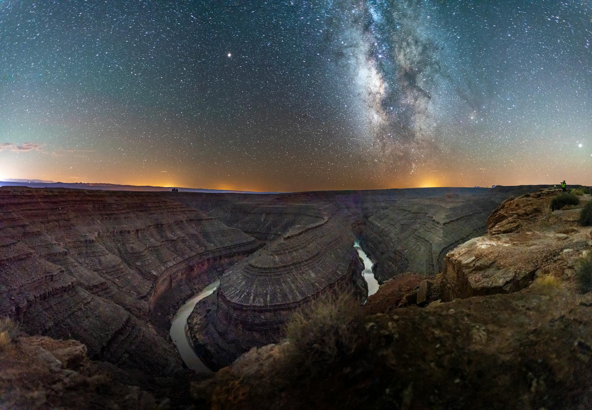 Vast starry sky above the winding San Juan River at Goosenecks State Park, Utah.