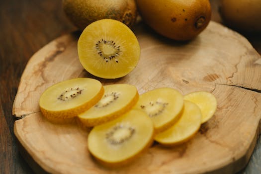 Delicious slices of golden kiwi on a wooden board, showcasing fresh and healthy fruit.