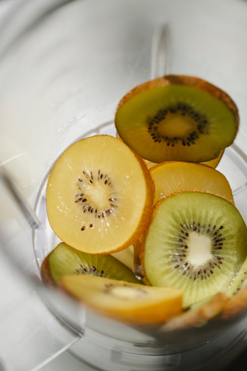 From above of slices of fresh kiwi placed in blender for vitamin refreshing smoothie